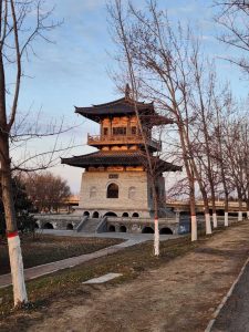 A peaceful sunset view of a traditional pagoda-style building surrounded by bare winter trees, creating a calm and historic atmosphere.